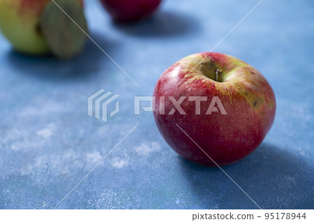 Fresh red apple freslhy picked, on blue background, lifestyle food photo, copy space Fresh red apple freslhy picked, on blue background, lifestyle food photo, copy space 95178944