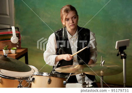 Mood, tone, atmosphere. Young girl, rock musician recording music video blog home lesson, playing drums or making broadcast internet tutorial 95179731