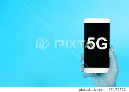 Creative background, hand holding a phone with a symbol 5G. The concept of 5G network, high-speed mobile Internet, new generation networks Creative background, hand holding a phone with a symbol 5G. The concept of 5G network, high-speed mobile Internet, new generation networks 95179732