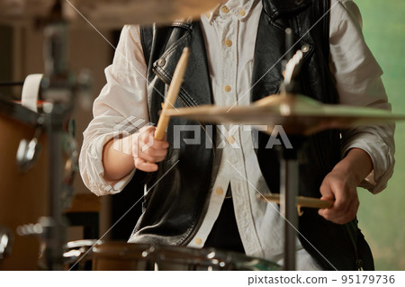 Drummer's rehearsing on drums before rock concert. Woman recording music on drumset in studio. Close up 95179736