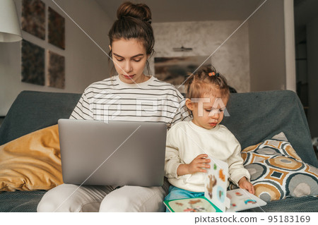 Busy freelance mother and child sitting on the sofa in the room 95183169