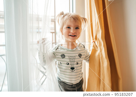Cheerful child posing for the camera against the window 95183207