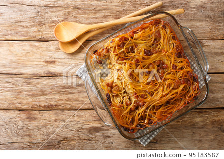 Delicious homemade Jerusalem kugel with noodles, raisins, cinnamon and sugar close-up in a glass bowl. Horizontal top view Delicious homemade Jerusalem kugel with noodles, raisins, cinnamon and sugar close-up in a glass bowl. Horizontal top view 95183587
