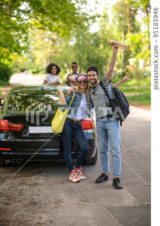 Cute young couple looking excited and joyful standing near the car Cute young couple looking excited and joyful standing near the car 95183946