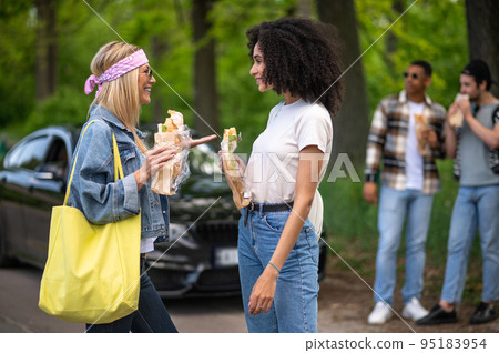Young people eating sandwiches and looking joyful Young people eating sandwiches and looking joyful 95183954