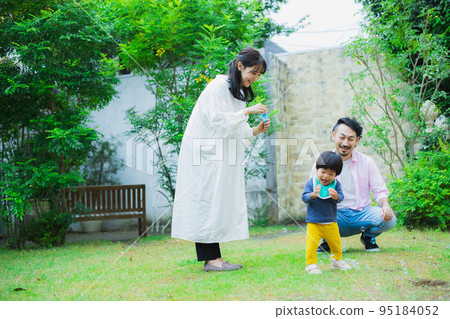 A family blowing soap bubbles in the garden 95184052