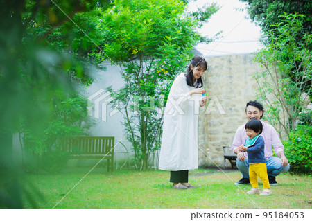 A family blowing soap bubbles in the garden 95184053
