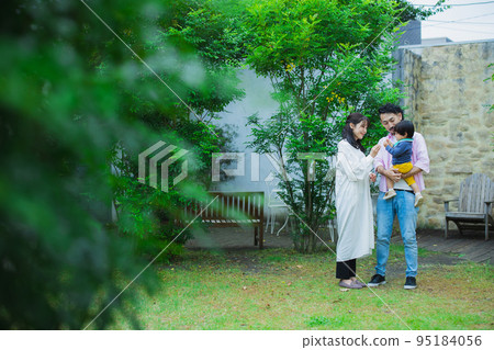 A family blowing soap bubbles in the garden 95184056