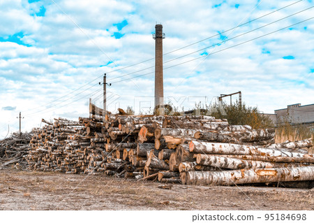 A pile of logs with a big chimney on background A pile of logs with a big chimney on background 95184698