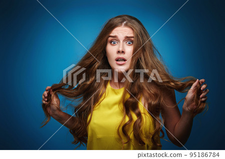 young woman in yellow t-shirt on blue background. young woman in yellow t-shirt on blue background. 95186784