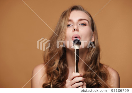 curly woman with make-up brush for powder 95186799