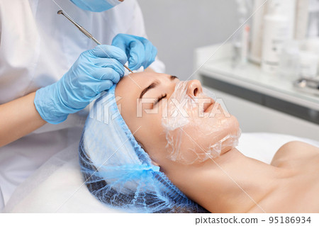 woman during a mechanical face cleansing procedure 95186934