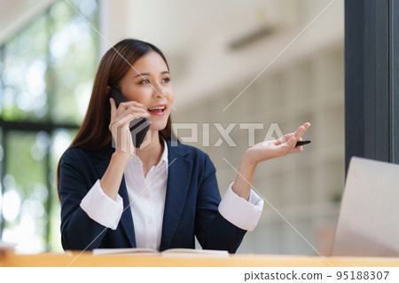 Asian Business woman making business call talking on phone. Account and Finance concept 95188307