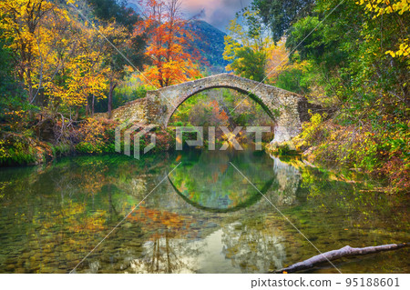 Ancient roman bridge surrounded by yellow trees Ancient roman bridge surrounded by yellow trees 95188601