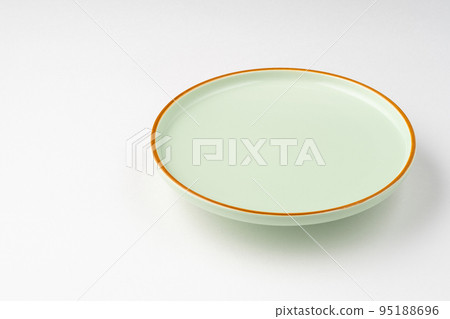 The pastel green ceramic plate with orange outlines on a white background 95188696