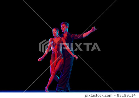 Feelings in dance. Emotional dancers dancing ballroom dance isolated on dark background. Concept of art, dance, beauty, music, style. Feelings in dance. Emotional dancers dancing ballroom dance isolated on dark background. Concept of art, dance, beauty, music, style. 95189114