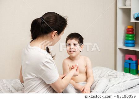 Mom gives a pill to the child, treating the children at home. Childhood diseases, dietary supplements or vitamin D. Mom gives a pill to the child, treating the children at home. Childhood diseases, dietary supplements or vitamin D. 95190059