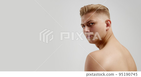 Portrait of young man posing shirtless isolated over grey studio background. Side view, flyer Portrait of young man posing shirtless isolated over grey studio background. Side view, flyer 95190745
