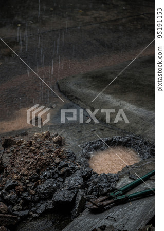 Broken leak water pipe busting at front of home during rain. Visible hole in the ground with Bolt cutter on old concrete and debris. Broken leak water pipe busting at front of home during rain. Visible hole in the ground with Bolt cutter on old concrete and debris. 95191153
