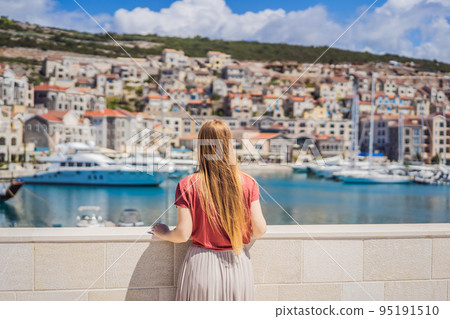 Woman tourist enjoying the views of Architecture and luxury yachts in Lustica Bay, Montenegro. Travel around Montenegro concept. Go Everywhere 95191510