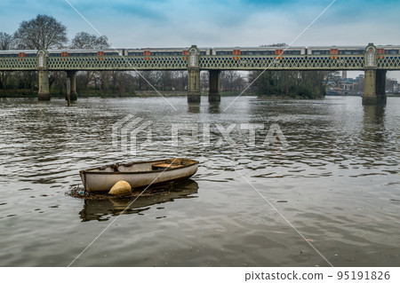 a rowing boat parked in the waters of the Thames. 95191826