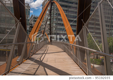 A bridge towards a modern looking building. building and the bridge which are situated in a business park. A bridge towards a modern looking building. building and the bridge which are situated in a business park. 95192035