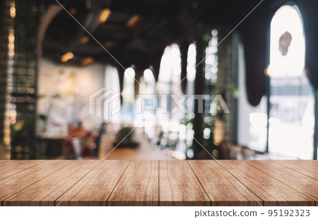 Empty wooden table top with lights bokeh on blur restaurant background. Empty wooden table top with lights bokeh on blur restaurant background. 95192323