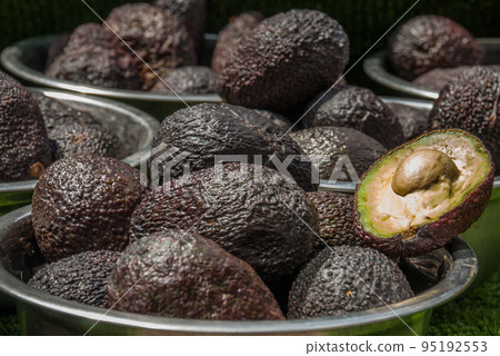 Avocados. One of them is opened that the stone and the pulp are visible Avocados. One of them is opened that the stone and the pulp are visible 95192553