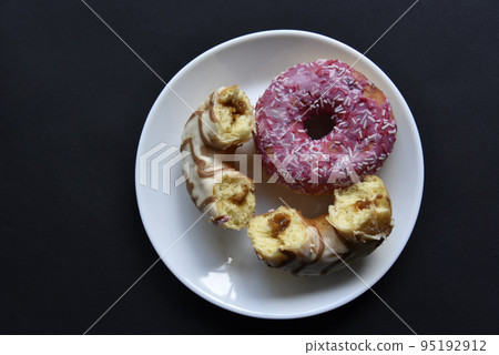 Delicious sweet donuts on a white plate. Donuts in glaze with filling close-up. 95192912