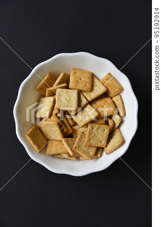 Delicious peppery cookies in a white plate on a black background. 95192914