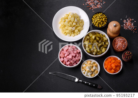 Delicious fresh Olivier salad with sausage, egg, cucumber, green peas, carrots and mayonnaise 95193217