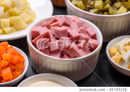 Delicious fresh Olivier salad with sausage, egg, cucumber, green peas, carrots and mayonnaise Delicious fresh Olivier salad with sausage, egg, cucumber, green peas, carrots and mayonnaise 95193226