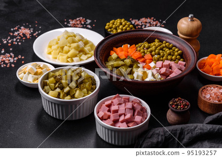 Delicious fresh Olivier salad with sausage, egg, cucumber, green peas, carrots and mayonnaise Delicious fresh Olivier salad with sausage, egg, cucumber, green peas, carrots and mayonnaise 95193257