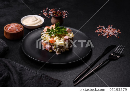 Delicious fresh Olivier salad with sausage, egg, cucumber, green peas, carrots and mayonnaise 95193279