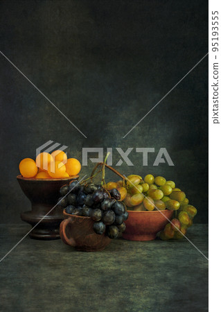 Still life with ripe grapes and orange balls 95193555