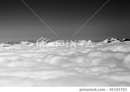 Mountains under clouds in sun winter day. Black and white. 95193783