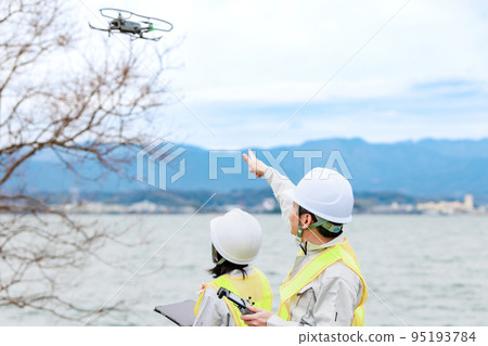 Workers operating drones 95193784