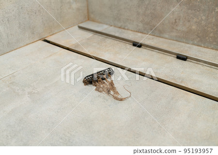 Removing hair clump from the shower drain. 95193957