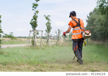 worker cutting grass worker cutting grass 95194228