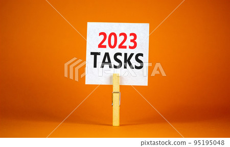 2023 Tasks symbol. White paper with words 2023 Tasks, clip on wooden clothespin. Beautiful orange table orange background. Business and 2023 tasks concept. Copy space. 2023 Tasks symbol. White paper with words 2023 Tasks, clip on wooden clothespin. Beautiful orange table orange background. Business and 2023 tasks concept. Copy space. 95195048