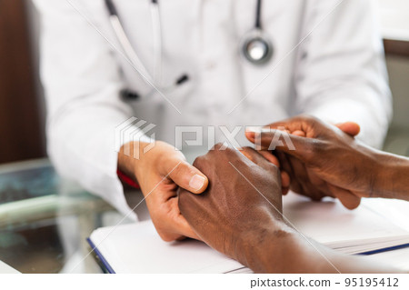 Friendly doctor hands holding patient hand support and hope concept Friendly doctor hands holding patient hand support and hope concept 95195412
