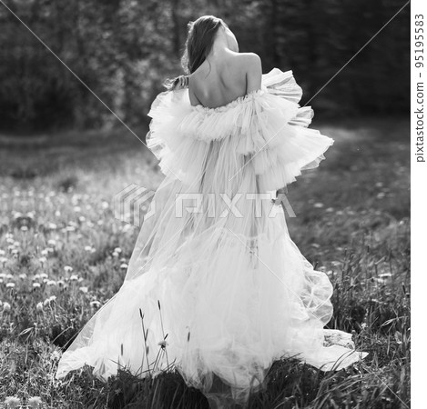 Sexy blonde in a chic classic dress posing in nature. 95195583