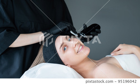 Woman on ultrasonic cleaning procedure. Hardware cosmetology.  95196042