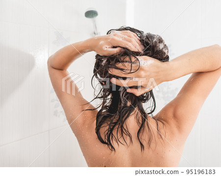 Naked woman with long hair takes a shower. Woman washes her hair with shampoo. Morning routine in modern urban apartment. White bathroom. Naked woman with long hair takes a shower. Woman washes her hair with shampoo. Morning routine in modern urban apartment. White bathroom. 95196183