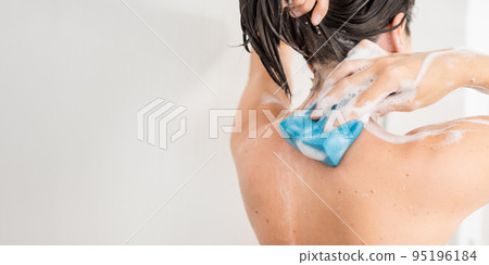 Naked woman with takes a shower. Woman washes her arms with shower gel and blue washcloth. Morning routine in urban apartment. Horizontal banner with copy space. Naked woman with takes a shower. Woman washes her arms with shower gel and blue washcloth. Morning routine in urban apartment. Horizontal banner with copy space. 95196184
