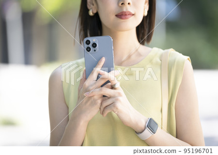 Young woman's hand holding a smartphone 95196701