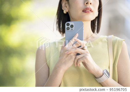 Young woman's hand holding a smartphone 95196705