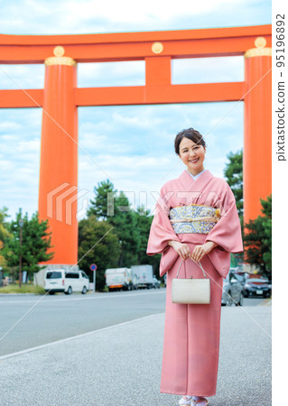 A woman in a kimono enjoying sightseeing in Kyoto in front of Otorii 95196892