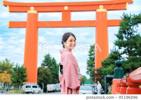A woman in a kimono enjoying sightseeing in Kyoto in front of Otorii 95196896