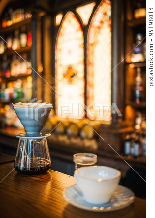 Coffee maker and cup on a bar counter close-up view 95198013